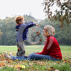 Child throwing autumn leafs