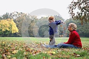 Child throwing autumn leafs