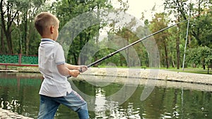 Child throws a fishing rod in the lake and catch fish