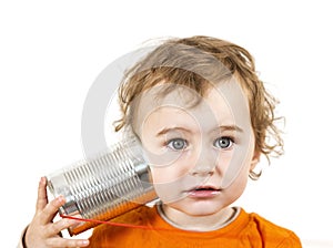 Child with tin can phone looking to camera