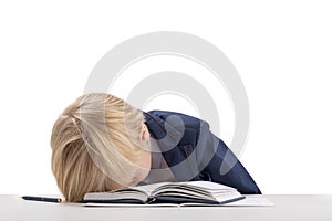 Child is tired of learning. Boy in school uniform put his head on book. Portrait of bored schoolboy on white background