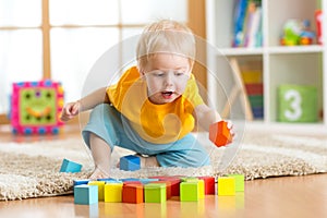 Child toddler playing wooden toys at home