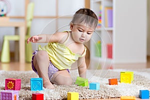 Child toddler playing wooden toys at home