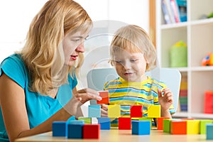 Child together with mother playing educational toys