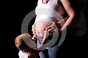 Child touching pregnant belly