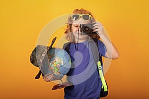 Child tourist explorer with globe world. Studio portrait of a little boy exploring world wildlife. Hiking and adventure