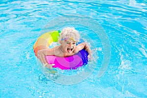 Child with toy ring in swimming pool