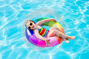 Child with toy ring in swimming pool