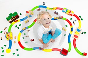 Child with toy train. Kids wooden railway.