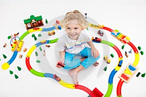 Child with toy train. Kids wooden railway