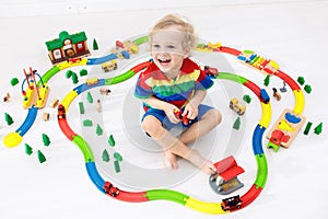 Child with toy train. Kids wooden railway