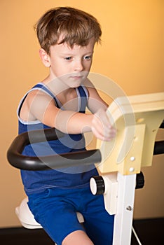 The child is trained on a stationary bike . Healthy lifestyle.