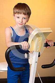 The child is trained on a stationary bike . Healthy lifestyle.