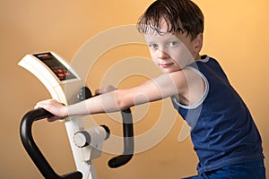 The child is trained on a stationary bike . Healthy lifestyle.