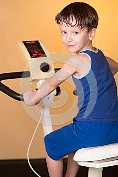 The child is trained on a stationary bike . Healthy lifestyle.