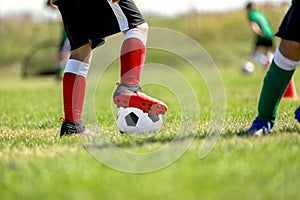 Child training soccer on fresh grass pitch. Soccer sports camp for kids. Boys practice dribbling in a field. Player develop dribbl