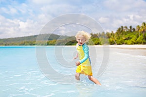 Child on tropical beach. Sea vacation with kids