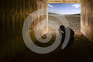 Child in tunnel and Cracked soil background with blue sky