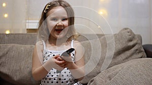 Child turns on the TV using the remote. Baby girl watching television