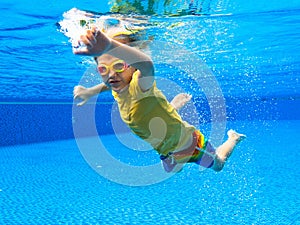 Child underwater in swimming pool. Kids swim