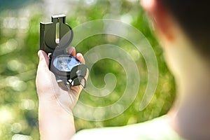 Child using a compass for navigation by a lake