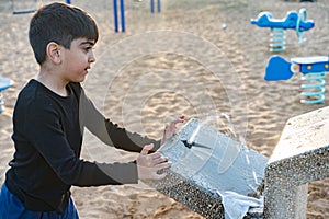 A child is using a dirty water tap