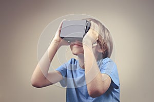 Child using new Virtual Reality, VR cardboard glasses