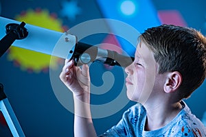 Child using telescope to watch galaxy