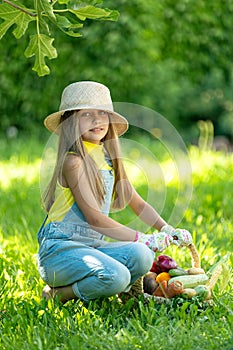 Child with vegetables. Happy little girl holding vegetables in her hands.