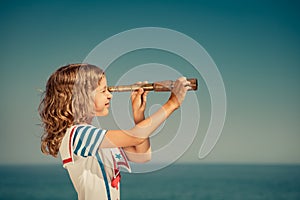 Child with vintage spyglass on summer vacation