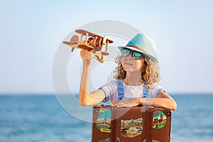 Child with vintage suitcase on summer vacation