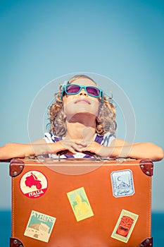 Child with vintage suitcase on summer vacation
