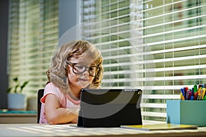 Child in virtual class. School at home. Homeschool little boy student learning in online class with teacher by remote