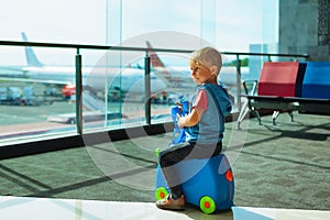 Child waiting for boarding to flight in airport transit hall
