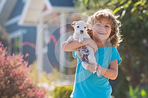 Child walk with a dog outdoor. Cute kid hug puppy.