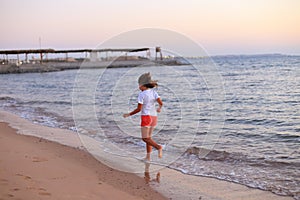 Child walking on the beach at dawn
