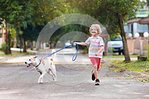 Child walking dog. Kids and puppy. Boy and pet