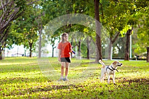 Child walking dog. Kids and puppy. Girl and pet