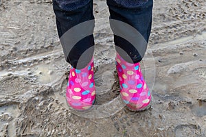 child walking in mud with boots