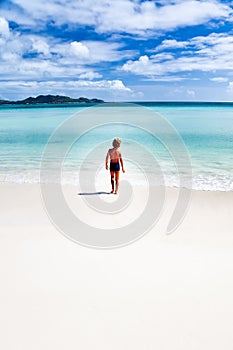 Child walking on a tropical beach