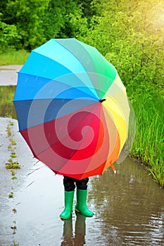 Child walking in wellies in puddle on rainy weather