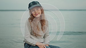 Child walks along the seashore. a little girl in warm clothes spends time on the beach