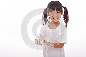 child washing hands and showing soapy palms.