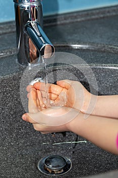 Child washing his hands to prevent illness