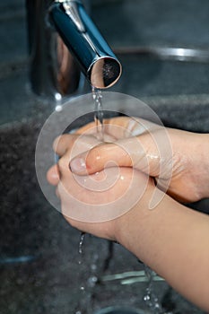 Child washing his hands to prevent illness