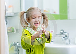 Child washing and showing soapy hands