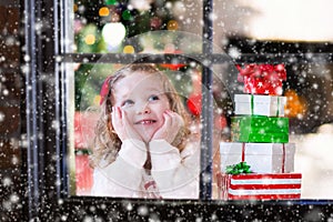 Child watching out of window on Christmas eve