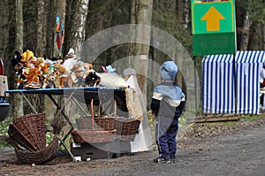 A child watching a toy stall. Wicker baskets, Bialowieza Forest. Object of desire. Children's dreams