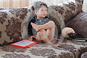 Child watching TV alone while sitting on the sofa