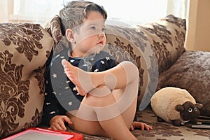 Child watching TV alone while sitting on the sofa